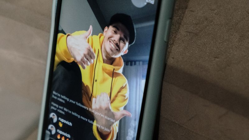 穿着黄色卫衣的创作者用手机做直播